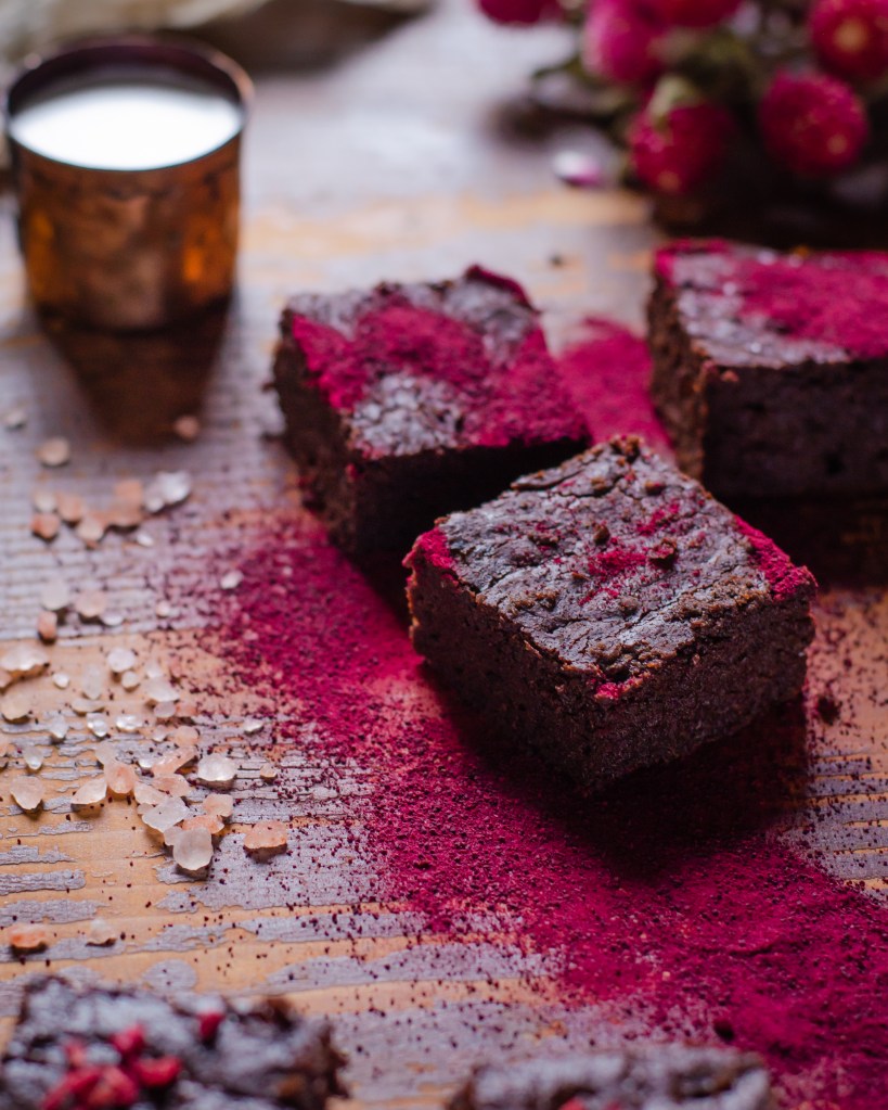 three slices of my fudgy beetroot brownies dusted with beetroot powder