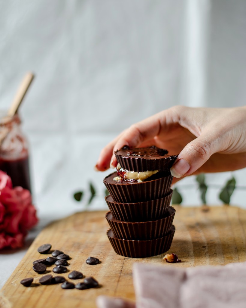 a stack of dark chocolate cups filled with PB&J